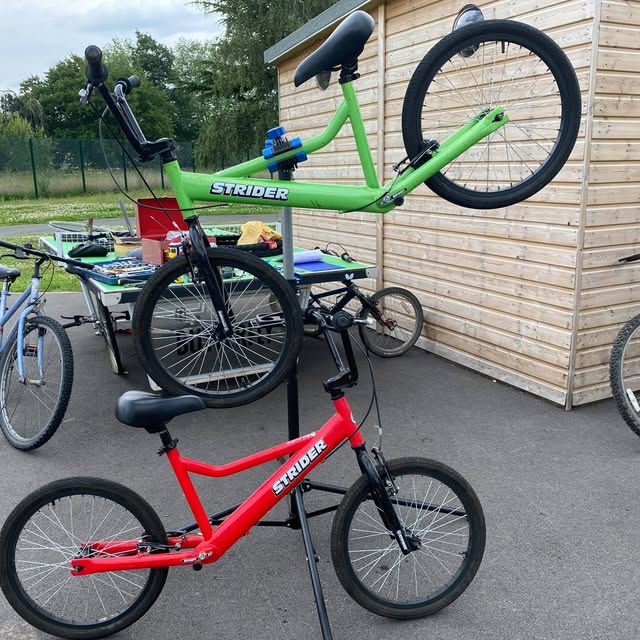 Two children's bikes on the workshop stand, serviced and ready to go
